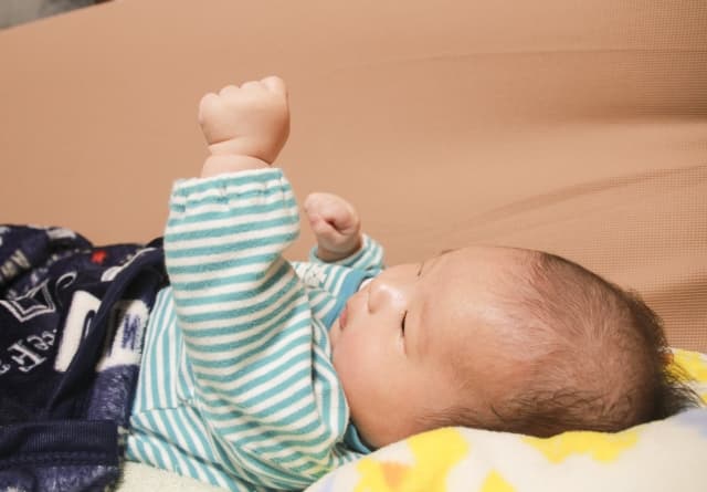 自分の手で遊んでいる乳幼児