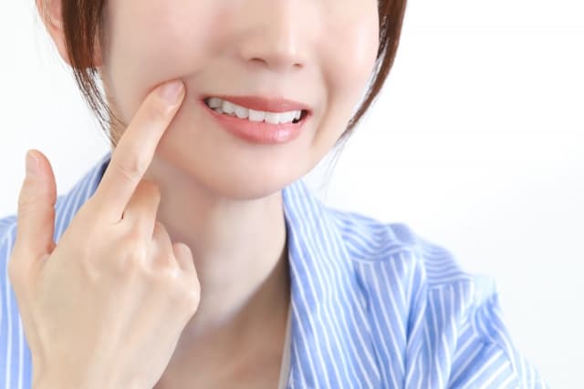 奥歯を指さす女性