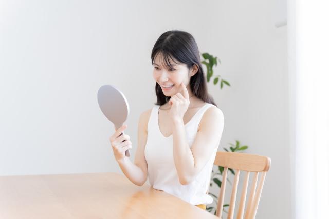 インプラントの歯を鏡で確認する女性
